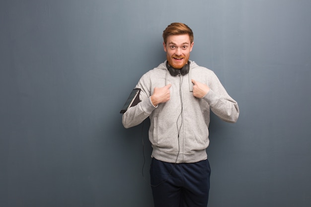 Young fitness redhead man surprised, feels successful and prosperous