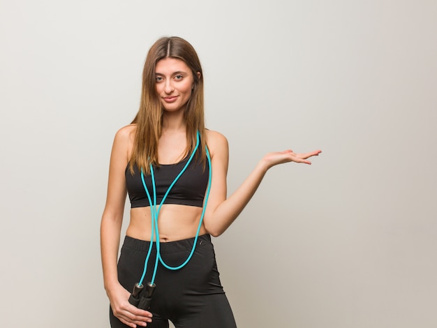 Young fitness russian woman holding something with hand. Holding a jump rope.