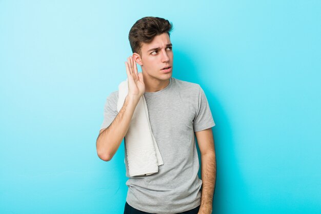 Young fitness teenager man trying to listening a gossip.