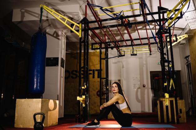 Young fitness woman execute exercise with exercisemachine Cable Crossover in gym horizontal photo