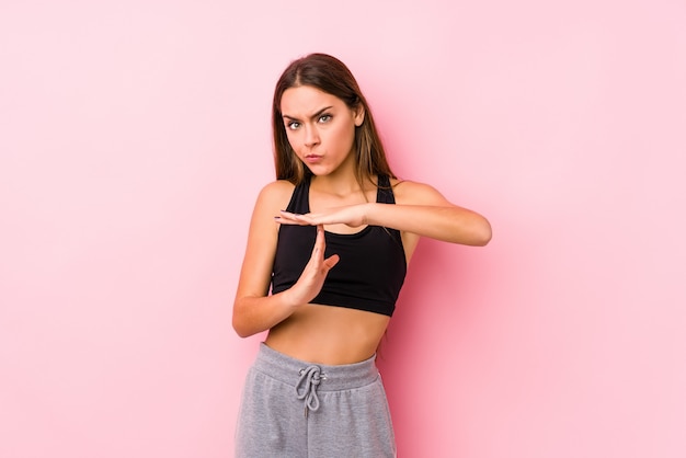 Young fitness woman posing and showing a timeout gesture