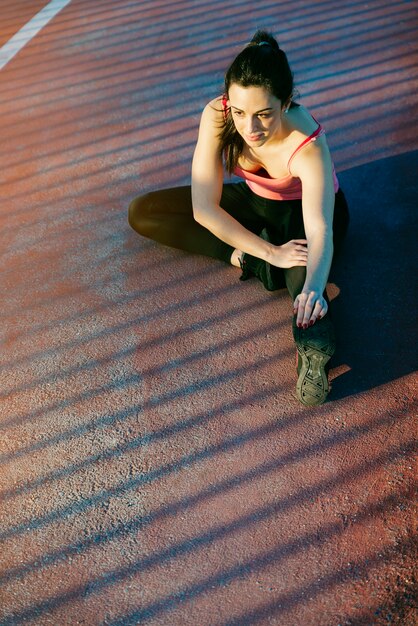 Young fitness woman runner stretching legs after run. Sport Concept.