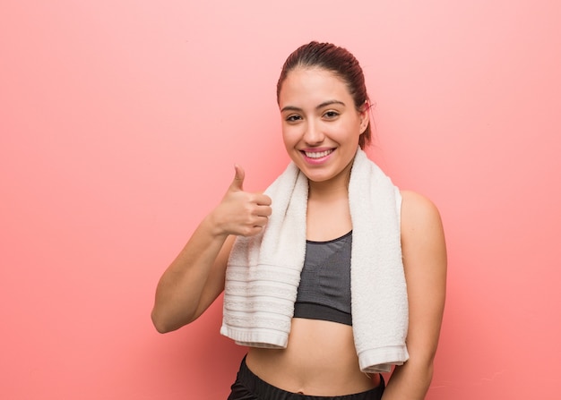 Young fitness woman smiling and raising thumb up