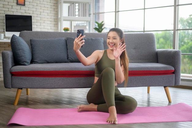 Young fitness woman in sportswear using smart phone while exercising at home Healthy and Lifestyles