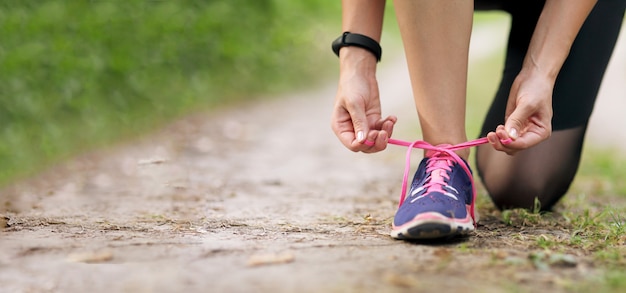 Young fitness woman tying shoelace running sneakers. healthy fit living.