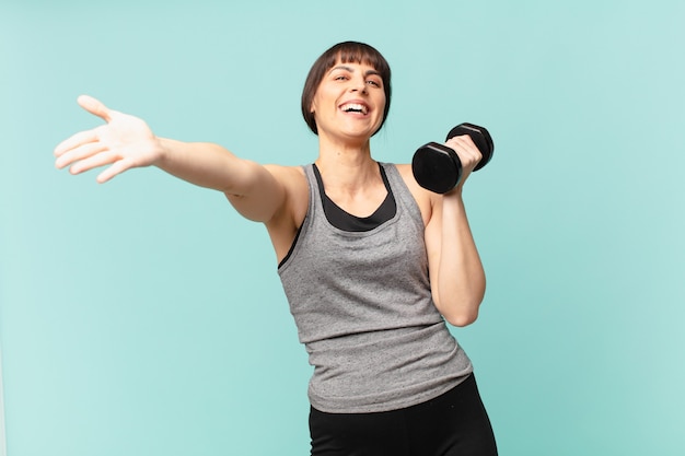 Young fitness woman with a dumbbell