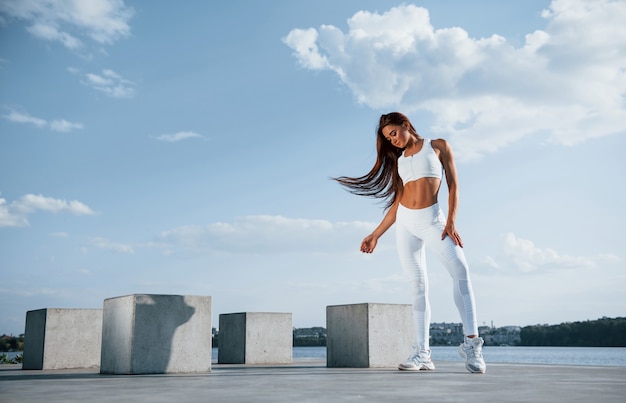 Young fitness woman with slim body type is outdoors