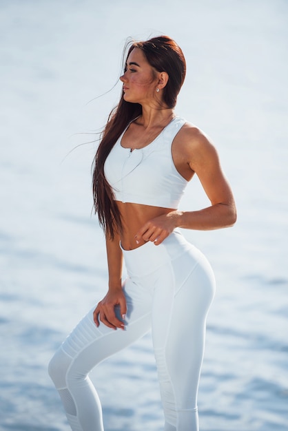  Young fitness woman with slim body type is outdoors.