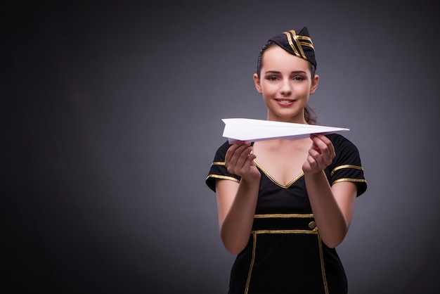 Young flight attendant on gray background