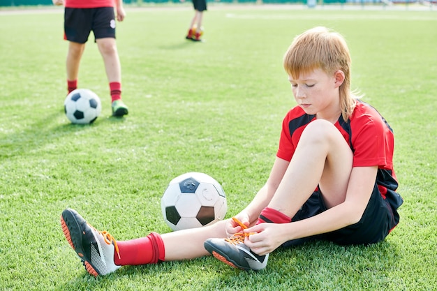 Young Football Player tying his shoes