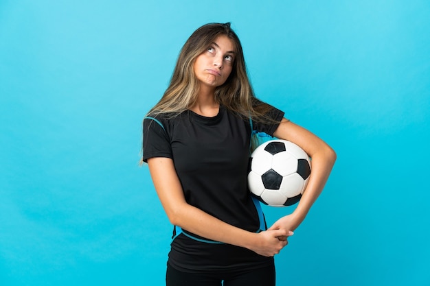 Young football player woman on blue and looking up