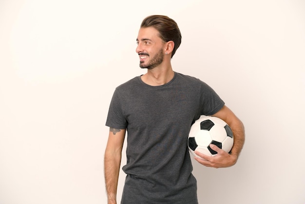 Young football player woman isolated on white background looking to the side and smiling