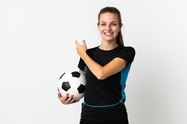 Young football player woman isolated on white background pointing to the side to present a product