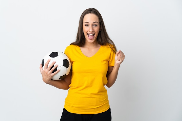 Young football player woman over isolated white wall celebrating a victory in winner position