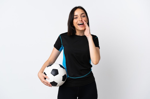 Young football player woman isolated on white wall shouting with mouth wide open