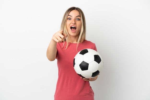 격리 된 흰 벽에 젊은 축구 선수 여자 놀고 앞을 가리키는