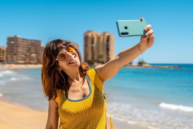 A young foreign tourist with the phone in Playa del Cura in the coastal city of Torrevieja, Alicante, Valencian Community