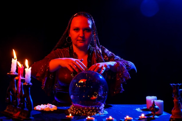 A young fortuneteller in the salon reads fortunes on a magic crystal Horizontal photo