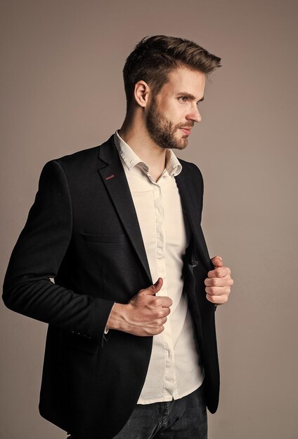 Young and free confident businessman in shirt and jacket boss male sexy ceo on gray background modern office life charismatic business owner stylish realtor handsome man wear formal suit