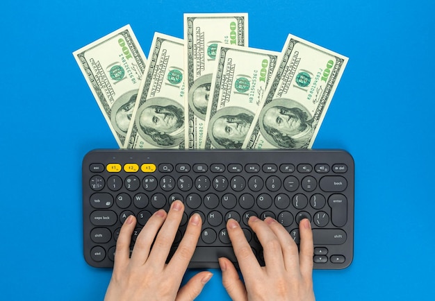 Young freelancer making money at home freelance concept Wireless keyboard and money dollar bills Work at home easy job concept Flat lay design top view and copy space photo