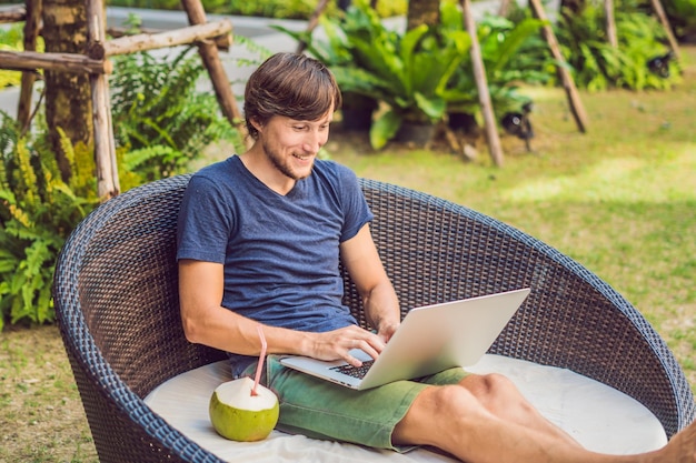 Young freelancer working on vacation next to the swimming pool