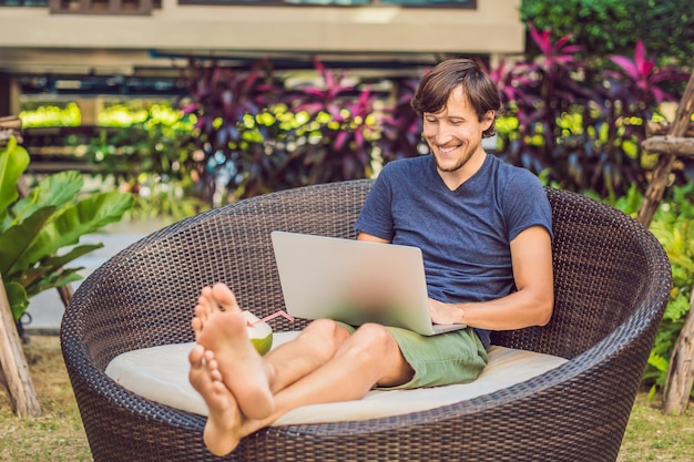 Young freelancer working on vacation next to the swimming pool