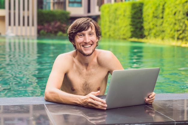 Young freelancer working on vacation next to the swimming pool