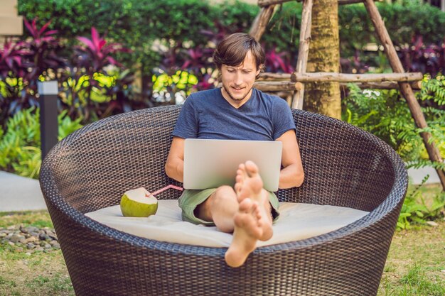 Young freelancer working on vacation next to the swimming pool.