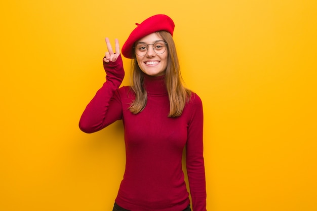 Young french artist woman fun and happy doing a gesture of victory