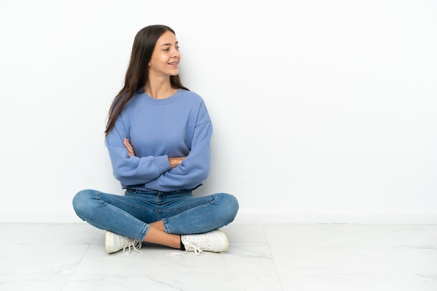 写真 横向きの位置で床に座っている若いフランスの女の子