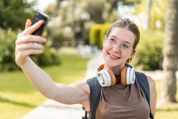 写真 セルフィーをしている外で眼鏡をかぶった若いフランス人女の子