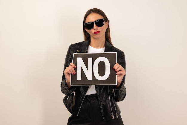 Photo young french woman isolated on white background holding a placard with text no