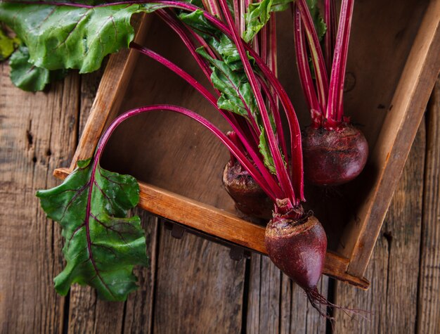 Young,fresh beets with tops on old wooden background