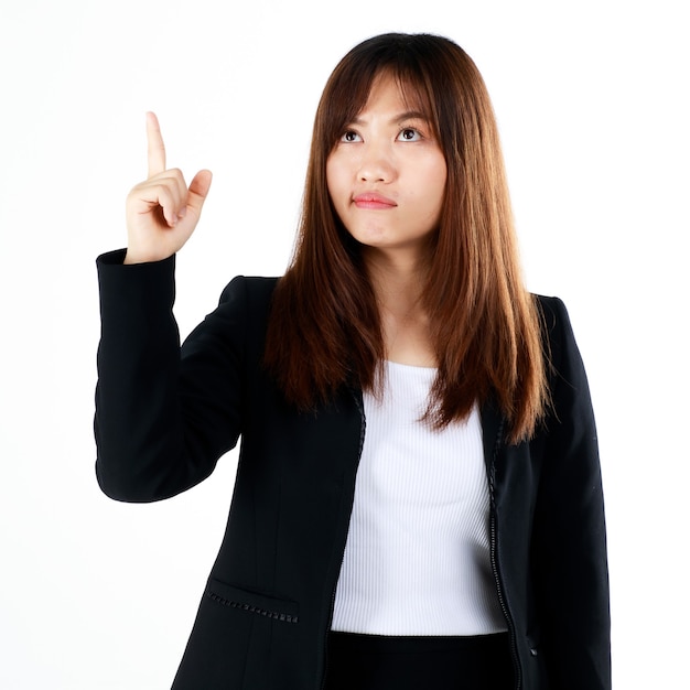 Young and fresh new graduated look Asian businesswoman in suit pose in advertising gesture, pointing finger to blank space for showing or presenting goods and products. Isolated on white background.