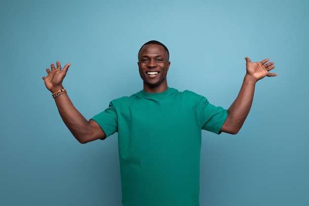 Young friendly american man in a tshirt on a blue background with copy space people lifesal concept