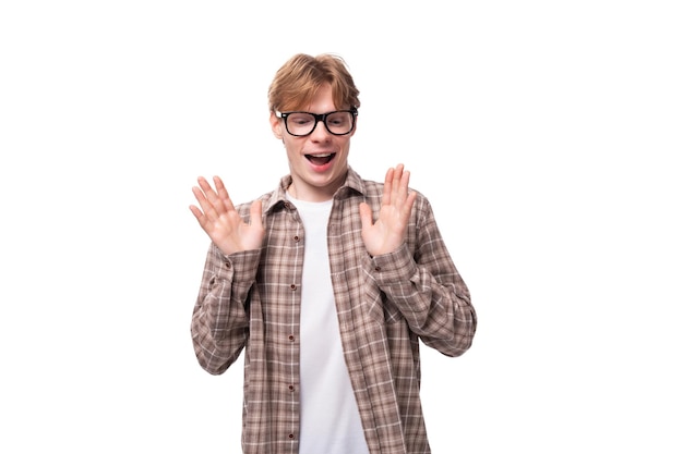 Young friendly caucasian redhaired guy in a shirt over a tshirt