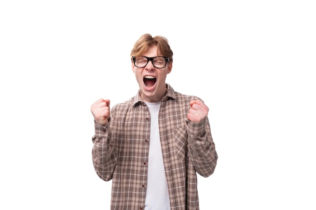 Young friendly caucasian redhaired guy in a shirt over a tshirt