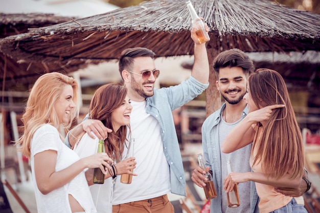 Young friends drinking beer and having fun outdoors