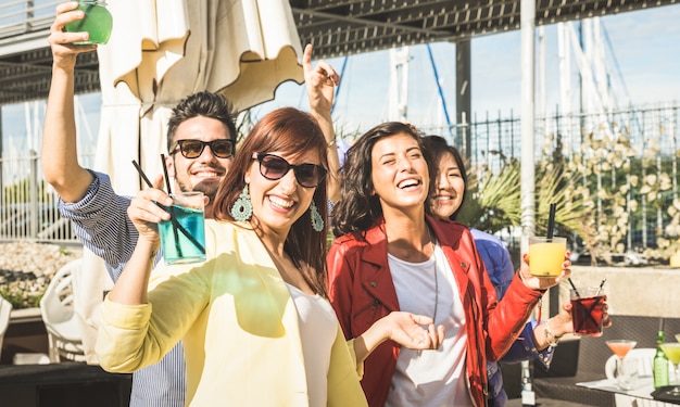 Young friends drinking and dancing at open air party