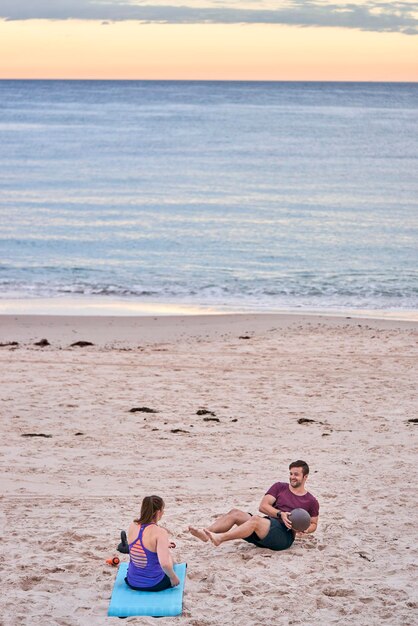 Young friends exercising at beach