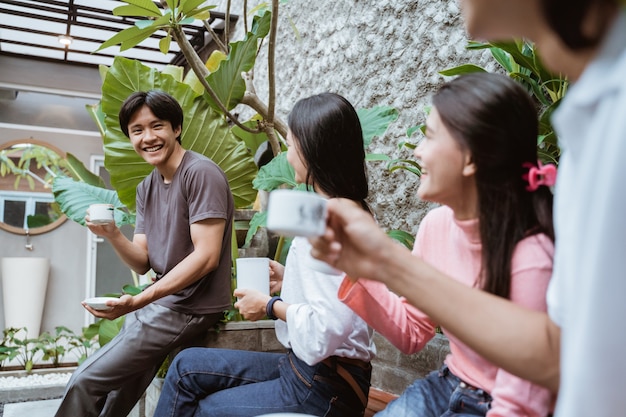 Young friends hanging out and enjoying drinks on backyard