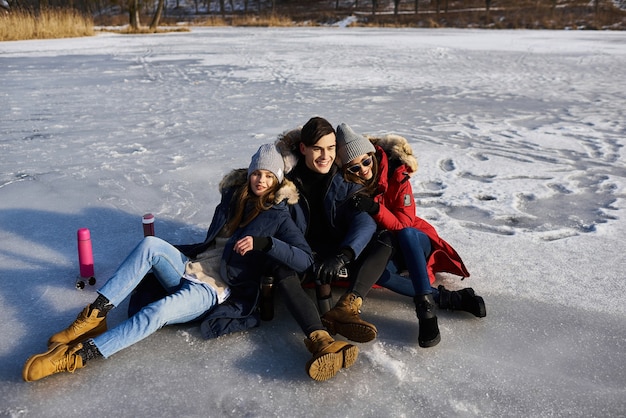 Giovani amici che hanno divertimento all'aperto nel periodo invernale