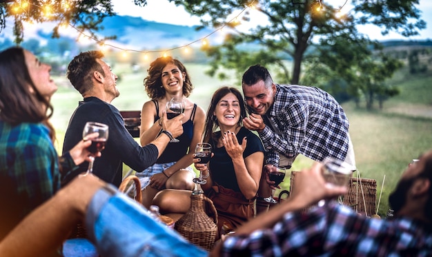 Young friends having fun at vineyard after sunset