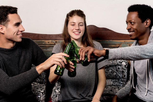 Young friends having fun with beers at home 