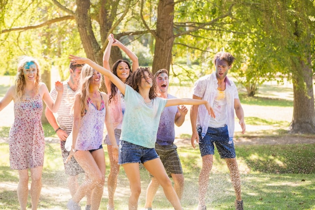 Young friends having fun with hose in the park