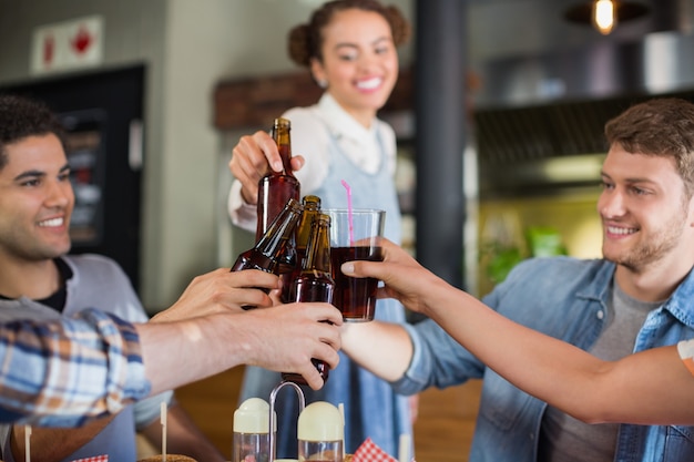 若い友人のパブでビール瓶を乾杯