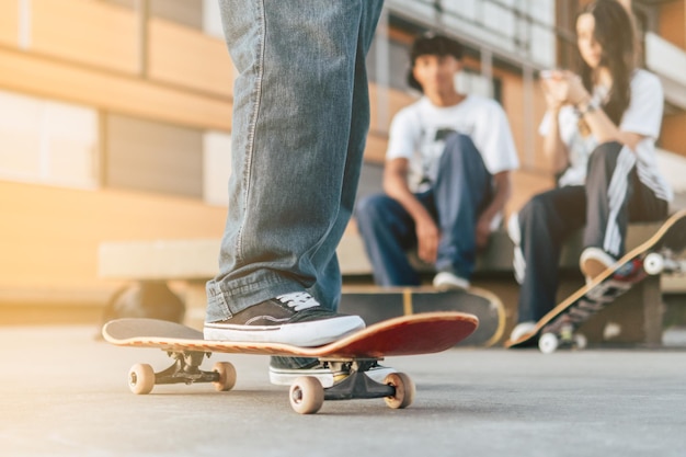 Young friends with skateboards outdoor on city skate park Teen friends having fun skating and listening music outside Extreme sport friendship youth concept Selective Focus