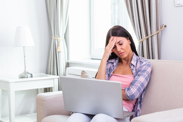 Photo young frustrated woman working from home in front of laptop suffering from chronic daily headaches treatment online appointing to a medical consultation electromagnetic radiation sick pay