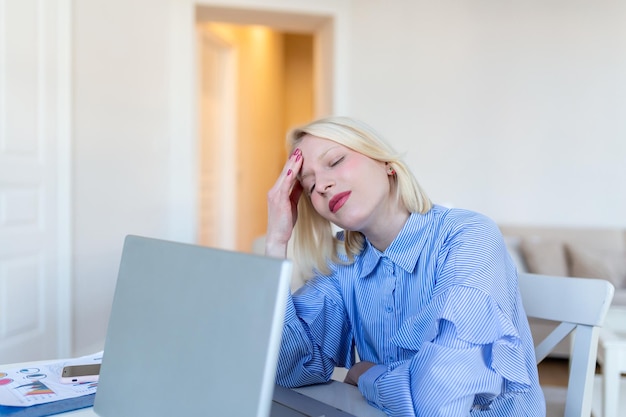 Молодая разочарованная женщина, работающая из домашнего офиса перед ноутбуком, страдающая от хронических ежедневных головных болей, онлайн-лечение, назначение на медицинскую консультацию, оплата больничного электромагнитного излучения