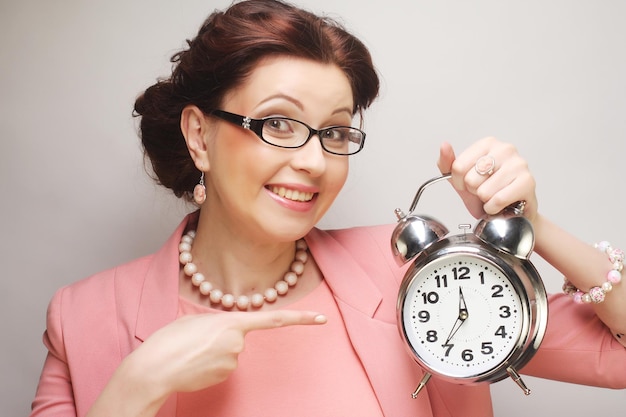 Young fun businesswoman with alarmclock